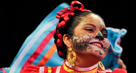 Image of a woman smiling. Her face is painted.