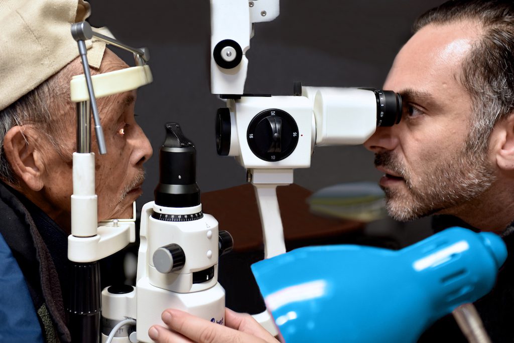 Someone getting an eye exam (eye exam equipment, eye doctor, lamp, patient)